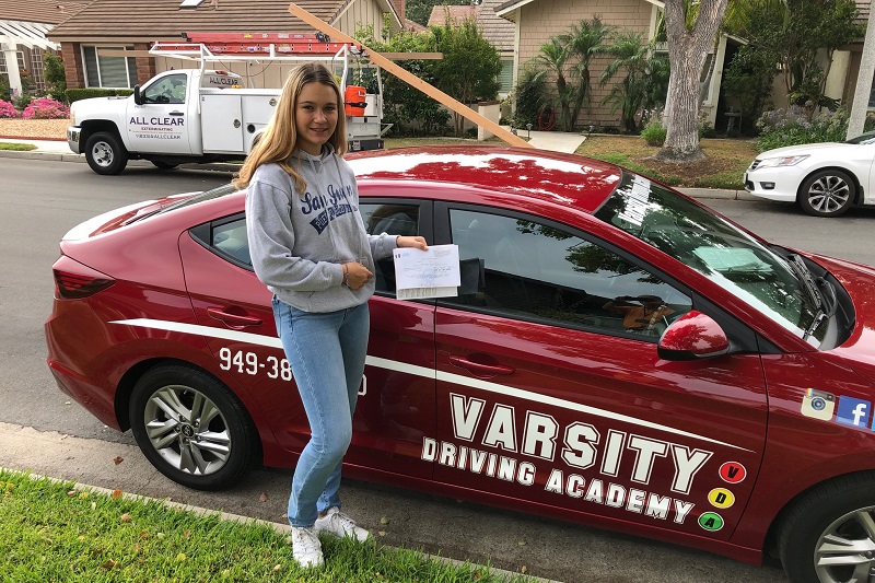 Driving Lessons in Costa Mesa Female Student Standing Next to a Training Vehicle