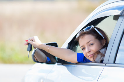 woman in a car holding keys in hand